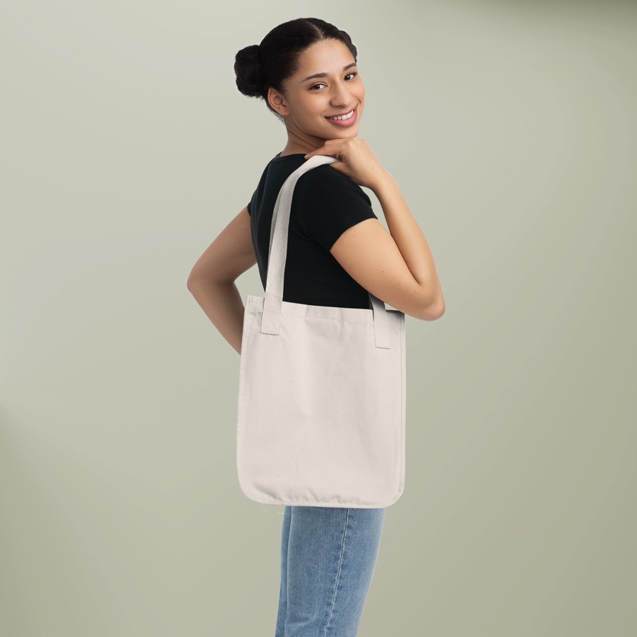 Woman carrying a natural-colored heavy organic canvas tote bag over her shoulder, Econscious blank
